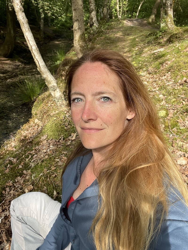 Portrait of Tanya Greene in a forest, soft daylight through the trees.
